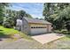 Spacious two-car garage with a wide driveway, offering ample parking and storage, surrounded by mature trees at 4104 Pebblebrook Sw Cir, Concord, NC 28027