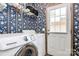 Convenient laundry room with modern washer/dryer and floral wallpaper at 4104 Pebblebrook Sw Cir, Concord, NC 28027