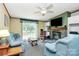 Inviting living room with a stone fireplace, ceiling fan, comfortable seating, and a sliding door to the outdoor deck at 4104 Pebblebrook Sw Cir, Concord, NC 28027