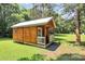 Rustic outbuilding with a porch, set in a lush green yard at 4104 Pebblebrook Sw Cir, Concord, NC 28027