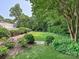 Lush backyard garden featuring manicured lawn, mature trees and beautiful flowerbeds at 4300 Cameron Oaks Dr, Charlotte, NC 28211
