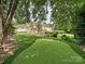 An expansive backyard featuring a custom putting green, manicured landscaping and beautiful rear exterior at 4300 Cameron Oaks Dr, Charlotte, NC 28211