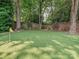 Backyard putting green surrounded by mature trees and a brick retaining wall at 4300 Cameron Oaks Dr, Charlotte, NC 28211