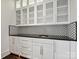 Bar area with white cabinets, black countertops, and patterned backsplash at 4300 Cameron Oaks Dr, Charlotte, NC 28211