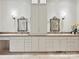 Bathroom featuring dual sinks, elegant mirrors, decorative sconces, and ample storage space at 4300 Cameron Oaks Dr, Charlotte, NC 28211