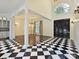 Stunning foyer with black and white checkered tile, chandelier, and black double doors at 4300 Cameron Oaks Dr, Charlotte, NC 28211