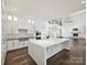 Open concept kitchen with white cabinets, large island and stainless appliances and view of the fireplace at 4300 Cameron Oaks Dr, Charlotte, NC 28211