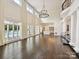 Spacious living room featuring hardwood floors, a chandelier, and access to the kitchen and pool at 4300 Cameron Oaks Dr, Charlotte, NC 28211