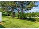 Lush green backyard with mature trees and a view of the community pool, perfect for outdoor relaxation and enjoyment at 5322 Jocelyn Ln, Charlotte, NC 28269