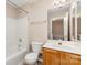 Bathroom with a single vanity, toilet, and shower-tub combo with neutral walls and wood look floor at 5322 Jocelyn Ln, Charlotte, NC 28269