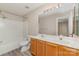 Bathroom featuring a double vanity, mirror, toilet and shower-tub combo with neutral paint at 5322 Jocelyn Ln, Charlotte, NC 28269