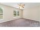 Bright bedroom with carpet flooring, neutral paint, and ceiling fan with large windows for natural light at 5322 Jocelyn Ln, Charlotte, NC 28269