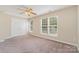 Neutral bedroom with ample natural light, carpet flooring, ceiling fan, and double door closet at 5322 Jocelyn Ln, Charlotte, NC 28269