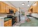 Modern kitchen with stainless steel appliances, hardwood cabinets, and green countertops, open to the dining area at 5322 Jocelyn Ln, Charlotte, NC 28269