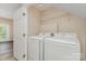 Bright laundry room featuring a washer and dryer with overhead shelving for organized storage at 5322 Jocelyn Ln, Charlotte, NC 28269