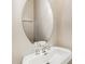 Neat half bathroom featuring a pedestal sink, chrome fixtures and an oval mirror, adding functionality and style at 5322 Jocelyn Ln, Charlotte, NC 28269