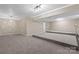 Large, finished basement space with carpet, neutral paint, and a raised platform area at 5916 Cashion Rd, Huntersville, NC 28078