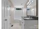 This bathroom features a white vanity, black countertop, white tiled shower/tub and window for natural light at 5916 Cashion Rd, Huntersville, NC 28078