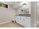 This bathroom features white cabinets, a dark countertop, a mirror, and updated lighting at 5916 Cashion Rd, Huntersville, NC 28078