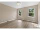 Bedroom with light tan walls, new flooring, and two bright windows with views of green foliage at 5916 Cashion Rd, Huntersville, NC 28078