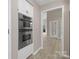 Hallway with stainless steel ovens, leading to rooms with light-colored walls and new floors at 5916 Cashion Rd, Huntersville, NC 28078