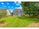 Large backyard with a green lawn, a patio with furniture, and a tall tree providing shade at 622 Lorain Nw Ave, Concord, NC 28027