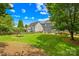 View of a well-maintained backyard with lush green grass, privacy fence, and patio with seating at 622 Lorain Nw Ave, Concord, NC 28027