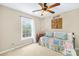 Bright bedroom with a colorful quilt, ceiling fan, and large window at 622 Lorain Nw Ave, Concord, NC 28027