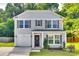 Charming two-story home featuring gray siding, symmetrical windows with dark shutters, and a one car garage at 672 Carybrook Ct, York, SC 29745