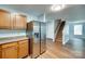 Modern kitchen featuring stainless steel refrigerator, wood cabinetry, and access to the staircase at 672 Carybrook Ct, York, SC 29745
