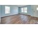 Bright living room with hardwood floors, featuring two large windows and a white door at 672 Carybrook Ct, York, SC 29745