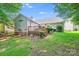 Home exterior featuring a wooden deck, lush landscaping, and a well-maintained lawn, ideal for outdoor living at 7033 Spandril Ln, Charlotte, NC 28215