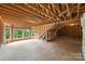 Unfinished attic space showing exposed wooden beams, three windows, and a concrete floor at 7319 Stonehaven Dr, Waxhaw, NC 28173