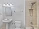 Well-lit bathroom featuring a walk-in shower, pedestal sink, and a classic white toilet at 7319 Stonehaven Dr, Waxhaw, NC 28173
