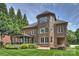 Elegant brick house showcasing a screened porch, backyard patio and lush landscaped garden at 7319 Stonehaven Dr, Waxhaw, NC 28173
