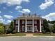 Stately brick home with grand columns, a pillared front terrace, and manicured landscaping at 7319 Stonehaven Dr, Waxhaw, NC 28173