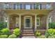 Inviting front porch with classic columns, brick steps, and manicured landscaping at 7319 Stonehaven Dr, Waxhaw, NC 28173