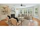 Bright living room with fireplace, built-in shelves, ceiling fan, hardwood floors, and lots of natural light at 7319 Stonehaven Dr, Waxhaw, NC 28173