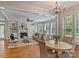 Open living room and dining area with hardwood floors, fireplace, and large windows with plantation shutters at 7319 Stonehaven Dr, Waxhaw, NC 28173