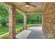 Covered back patio with brick columns, wood ceiling, fire pit and natural views at 7319 Stonehaven Dr, Waxhaw, NC 28173