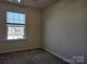Bright bedroom with a large window offering natural light and neutral carpeting at 7323 Jane Parks Way, Charlotte, NC 28217