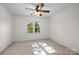 Bedroom featuring neutral carpet, ceiling fan, and a large window providing natural light at 765 Portpatrick Pl, Fort Mill, SC 29708
