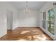 Spacious dining room with hardwood floors, decorative chandelier, and large windows showcasing the surrounding view at 765 Portpatrick Pl, Fort Mill, SC 29708