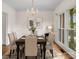 Elegant dining room with chandelier, modern art, table set for dinner and floor-to-ceiling window with natural light at 765 Portpatrick Pl, Fort Mill, SC 29708