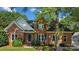 Charming brick home exterior featuring green shutters, dormer window, and mature landscaping at 765 Portpatrick Pl, Fort Mill, SC 29708
