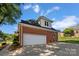 Side view of brick home showing two-car garage with white door and concrete driveway at 765 Portpatrick Pl, Fort Mill, SC 29708