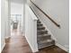 Inviting entryway with hardwood floors and carpeted stairs, leading to a bright kitchen in the background at 9142 Widden Way, Charlotte, NC 28269