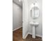 Stylish half-bathroom with a pedestal sink, modern lighting, and hardwood floors, offering convenience for guests at 9142 Widden Way, Charlotte, NC 28269