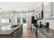 Modern kitchen featuring granite countertops, stainless steel appliances, and a sliding glass door to the backyard at 9142 Widden Way, Charlotte, NC 28269
