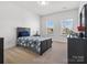 Well-lit bedroom with a full bed, two large windows, and neutral-colored carpet at 1001 Hampton Grove Rd, Waxhaw, NC 28173